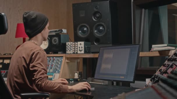 Genç Erkek Yapımcı Stüdyo Kayıt Stüdyosunda Oturmuş Müziği Düzenliyor Karıştırıyor — Stok video