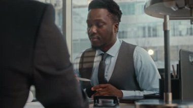 Zarif Afrikalı Amerikalı erkek girişimcinin belini kaldırın. Ortağıyla iş görüşmeleri yapıyor.