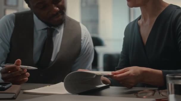 アフリカ系アメリカ人ビジネスマンが女性弁護士とのオフィスミーティングをしながら法的文書に署名 — ストック動画