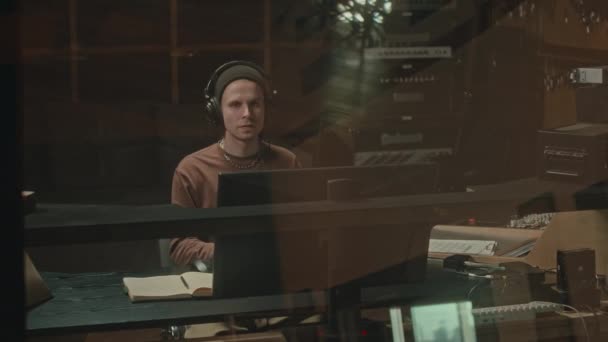 Jonge Blanke Man Platenproducent Koptelefoon Zittend Werkstation Geluidsstudio Muziek Makend — Stockvideo