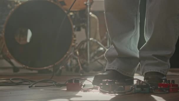在演播室里演奏时 低段穿着蓝色宽腿牛仔裤的无法辨认的音乐家按吉他效果踏板 — 图库视频影像