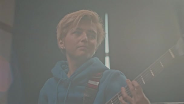 在烟烟熏的工作室里弹电吉他的年轻女吉他手的胸部 — 图库视频影像