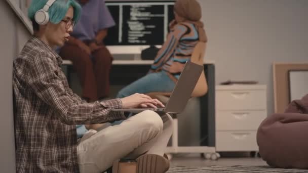 Ung Blåhåret Asiatisk Mandlig Programmør Trådløse Hovedtelefoner Sidder Gulvet Kontoret – Stock-video