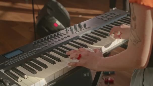 スタジオで情熱的にキーボードを演奏する認識できないタトゥーの女性ミュージシャンのクロップショット — ストック動画
