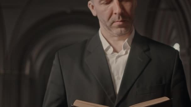 中年白种人天主教牧师在教堂礼拜中穿着合适阅读圣经的倾斜 — 图库视频影像