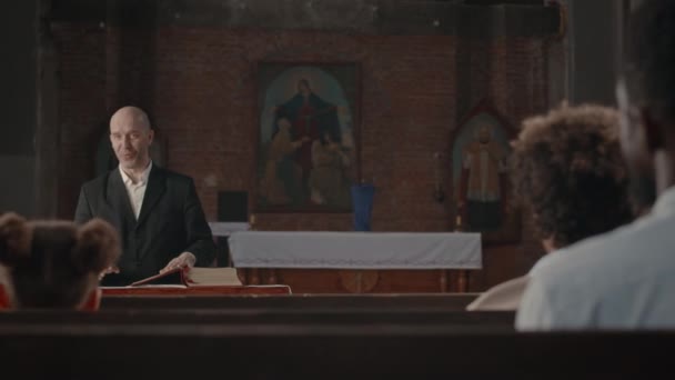 中年白种人光头牧师 身穿西服 与各种各样的教区居民交谈 为天主教堂举行宗教仪式 — 图库视频影像
