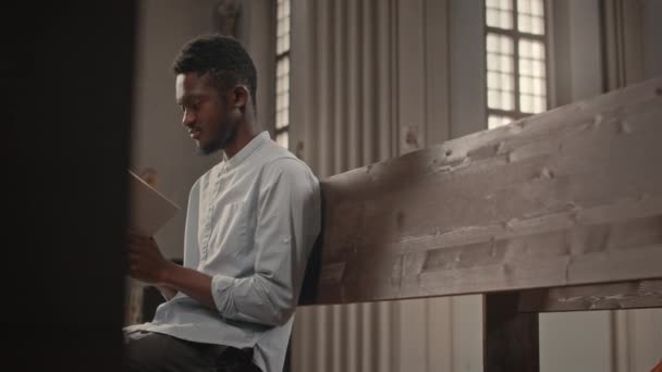 Střední Záběr Mladého Černocha Sedí Dřevěné Lavičce Katolické Církvi Čtení — Stock video