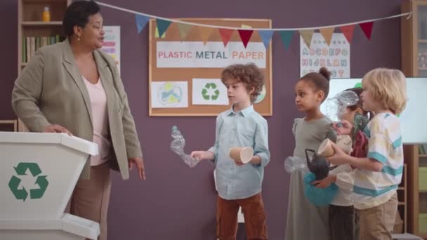 Wielokulturowe Dzieciaki Szkoły Podstawowej Sortują Śmieci Pojemników Śmieci Szkole — Wideo stockowe