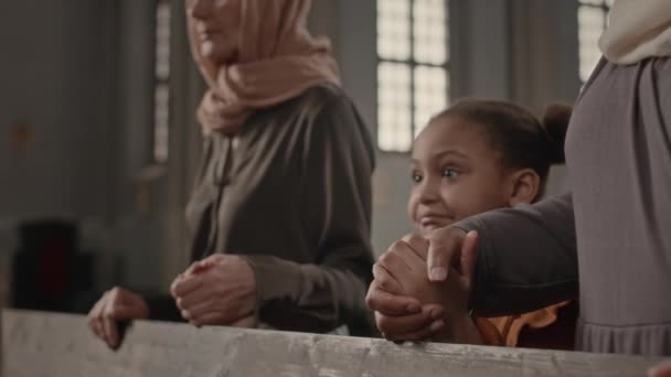6岁的非洲裔美国女孩与亲戚一起参加周日的教堂礼拜 站在两名多族裔妇女中间牵着手听布道 — 图库视频影像