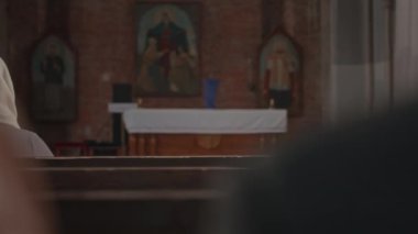Kilise cemaatinin, Katolik Kilisesi 'ndeki ahşap banklarda oturmaya başlamayı beklediği arka planı.