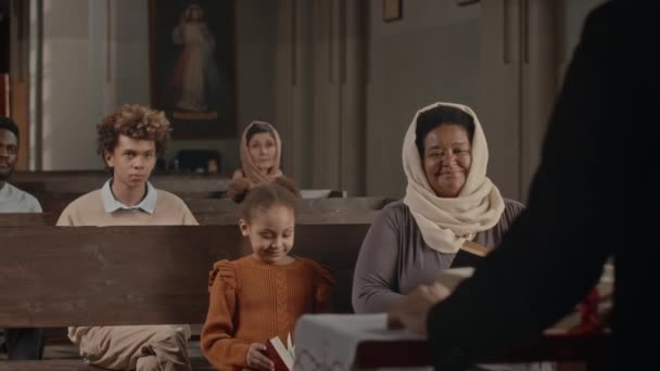 Gruppo Diversi Parrocchiani Seduti Sui Banchi Della Chiesa Cattolica Ascoltare — Video Stock