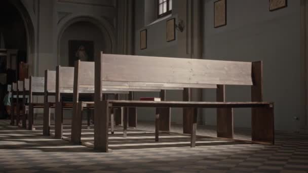 天主教教堂里 没有人在一排排空荡荡的木制长椅上闪烁着阳光 — 图库视频影像