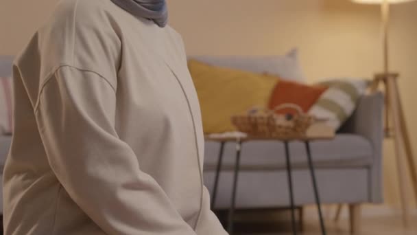 年轻的穆斯林妇女披着头巾在家里小腿上祈祷 — 图库视频影像