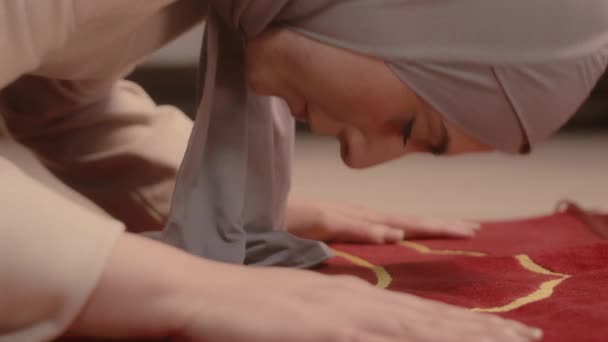 自宅でレッドカーペットで祈りを読むヒジャーブの若いムスリム女性の閉鎖 — ストック動画