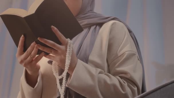 Niski Kąt Młodej Muzułmanki Różańcem Rękach Czytającej Wieczorem Świętą Księgę — Wideo stockowe