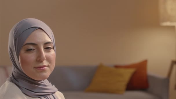 在舒适的客厅里摆姿势拍照 为年轻笑容满面的穆斯林妇女拍照 — 图库视频影像