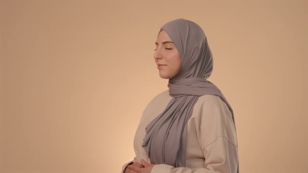 阿拉伯女青年头戴头巾 在彩色背景下摆好姿势拍照的中等画室肖像 — 图库视频影像