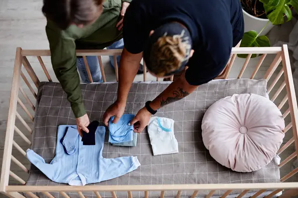 Top View Gay Couple Expecting Child Preparing Crib Baby Clothes — Stock Photo, Image