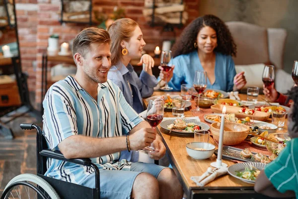 Portrait Smiling Young Man Wheelchair Enjoying Dinner Party Friends Holding — Stock Photo, Image