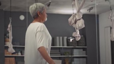 Orta boy, sağlıklı Asyalı bir kadının kapalı bir spor salonunda kardiyo eğitimi alırken ip atlaması.
