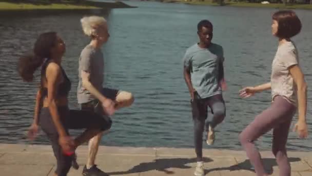 在阳光明媚的日子里 四个快乐的朋友在户外一起进行水上训练时 迅速跳了起来 — 图库视频影像