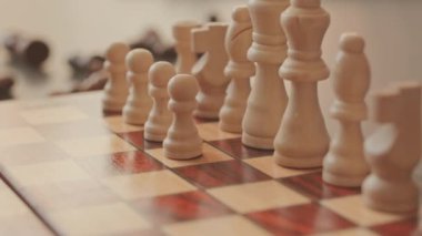 Tanınmayan satranç oyuncusunun yavaş yavaş yaklaşımı beyaz taşları tahta satranç tahtasına koyuyor