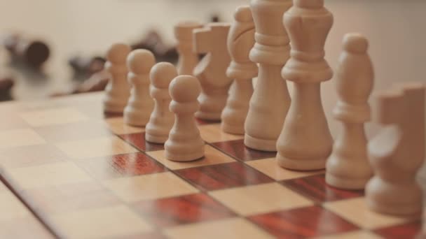 認識できないチェスプレーヤーのスローモークアップ 木製チェスボードに白い部分を列に置く — ストック動画