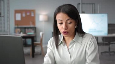 Masaüstü bilgisayarındaki meslektaşımla görüntülü görüşme sırasında iş raporundan bahseden neşeli, neşeli, melez esmer kadının sandığı.