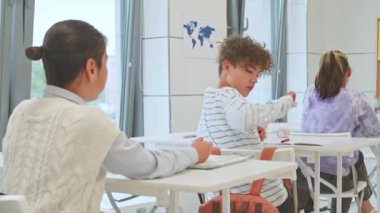 Sınıfta sınav yazarken kopya kağıdı geçiren çok ırklı sınıf arkadaşlarının belini bük