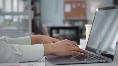 Ofisteki şirket bütçesini analiz ederken dizüstü bilgisayarda yazan tanınmayan iş kadınının yakınlaşması