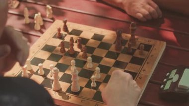 Yazın açık havada satranç oynayan iki son sınıf öğrencisi.