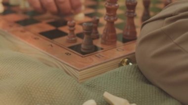 Arkadaşla açık havada satranç oynarken mat hareketi yapan tanınmayan adamı kapat.