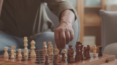 İçerideki ahşap masada satranç oynayan tanınmayan adamların kırpılmış vuruşları.