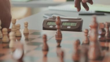 İki tanınmayan erkek rakibin kapalı alanda oynarken satranç saatinin düğmelerine basmasını kapat