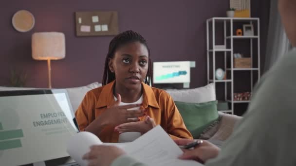 若いアフリカ系アメリカ人女性が現代のオフィスで女性のHrマネージャーの前に座っている就職インタビューで質問に答えるのを待つ — ストック動画