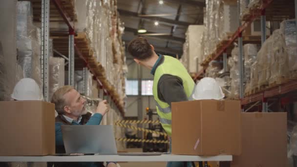 在对用纸板箱包装的货物进行库存盘点时 与年轻员工交谈的成熟仓库管理员中的镜头 — 图库视频影像