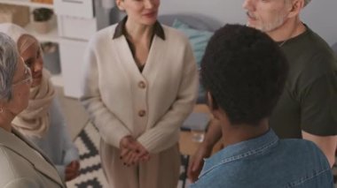 İçeride terapi seansı sırasında el çırpıp birbirlerine sarılan beş kişiden oluşan orta boy bir fotoğraf.