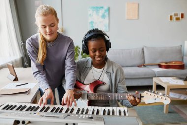 Birlikte müzik yapan ve stüdyoda ya da evde şarkı besteleyen iki genç kadının portresi.