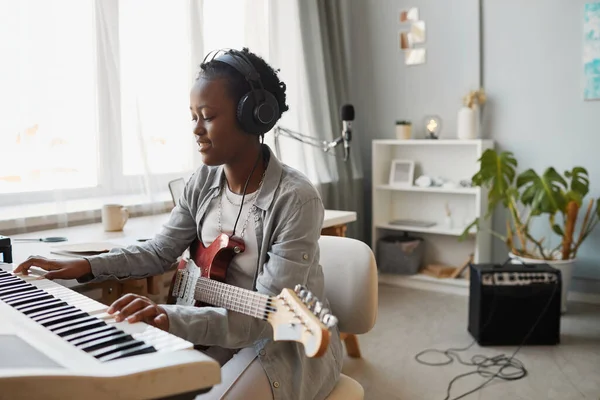 Minimaalinen Muotokuva Nuori Musta Nainen Pelaa Syntetisaattori Säveltäminen Musiikkia Kotona — kuvapankkivalokuva