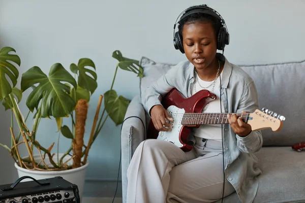 Minimaalinen Muotokuva Musta Nuori Nainen Soittaa Elektronista Kitaraa Kotona Laulaa — kuvapankkivalokuva