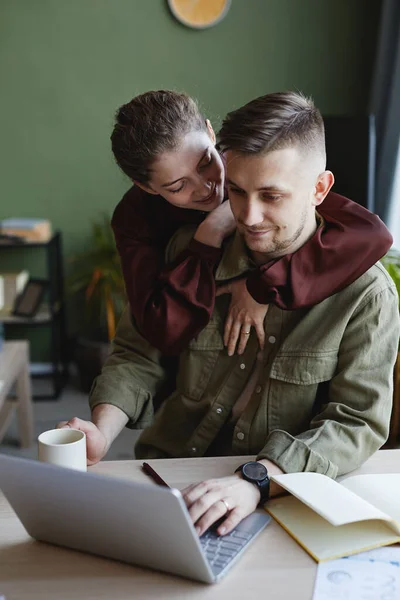 Young Smiling Woman Embracing Her Boyfriend While Doing His Online — Stock Photo, Image