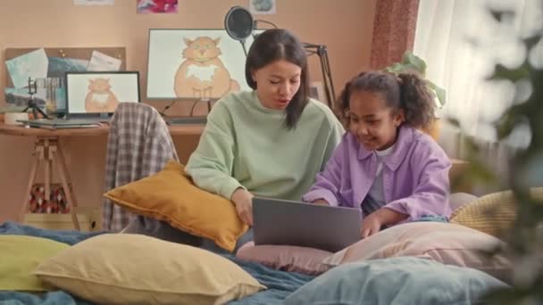 非洲裔美国人妈妈和10岁的女儿一起坐在明亮舒适的孩子卧室里柔软的床上 — 图库视频影像