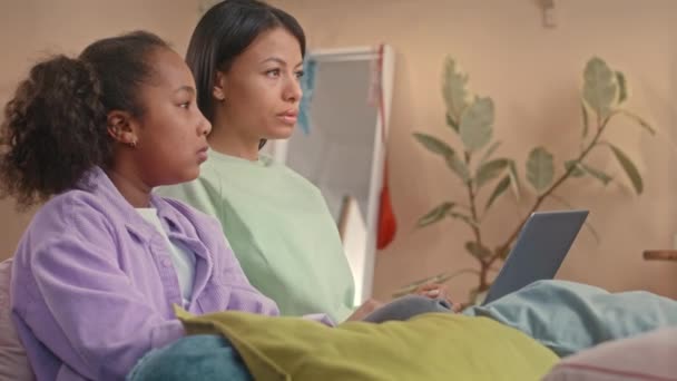 让快乐的年轻比拉西亚女人和她漂亮的10岁女儿一起在家里消磨时光 抱着笔记本电脑坐在孩子们的卧室里聊天 — 图库视频影像