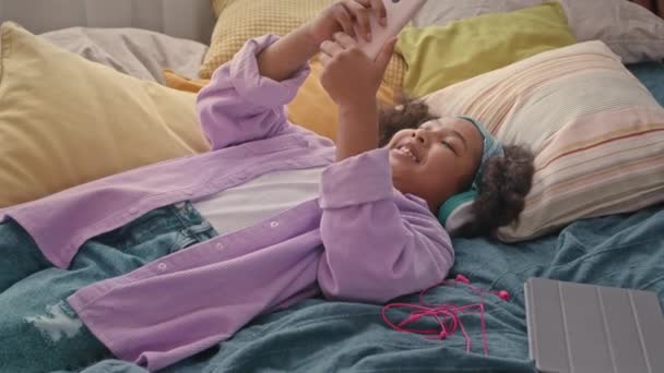 Χαρούμενη Αφρο Αμερικανίδα Gen Κοπέλα Ξαπλωμένη Μαλακό Κρεβάτι Στο Δωμάτιό — Αρχείο Βίντεο