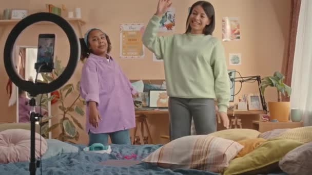 明るい子供の寝室でスマートフォンでトレンディなダンスビデオを撮影する芸術的なアフリカ系アメリカ人の母親と娘のミディアムショット — ストック動画