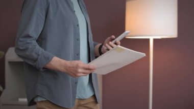 Evrakları ve akıllı telefonları olan tanınmayan bir işadamının ofis boyunca yürüdüğü görüntüler.