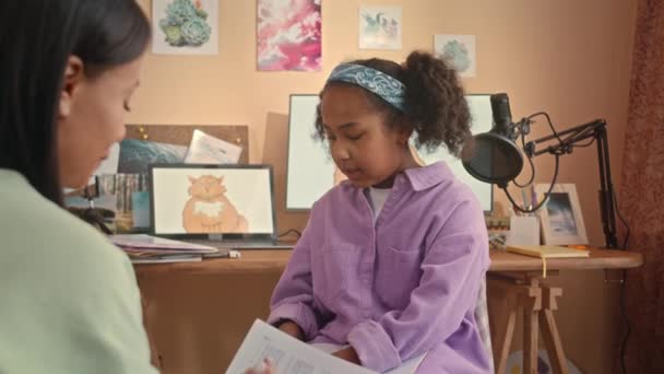 年轻的母亲帮助她10岁的女儿一起坐在舒适的孩子卧室里做数学作业 — 图库视频影像