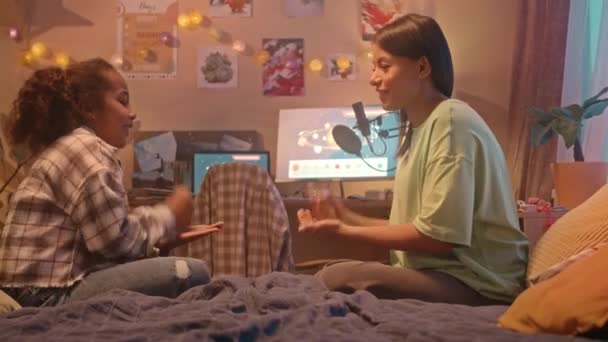 アフリカ系アメリカ人の母親と娘が夜に子供の寝室でベッドに座ってロックペーパーハサミのゲームをしている中型ショット — ストック動画