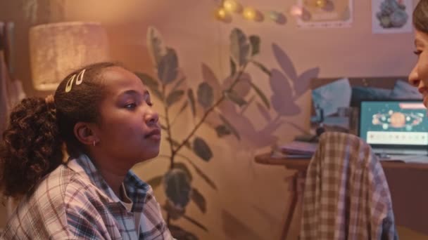 かわいい10歳のアフリカ系アメリカ人の少女のチェストアップは 夜に暖かい光で居心地の良い部屋で一緒にベッドに座っている間 ママとチャット — ストック動画