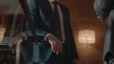 İki tanınmayan çoklu etnik girişimcinin orta kesimi modern ofiste parmaklıklar arkasında dikilip sohbet ederken el sıkışıyor.